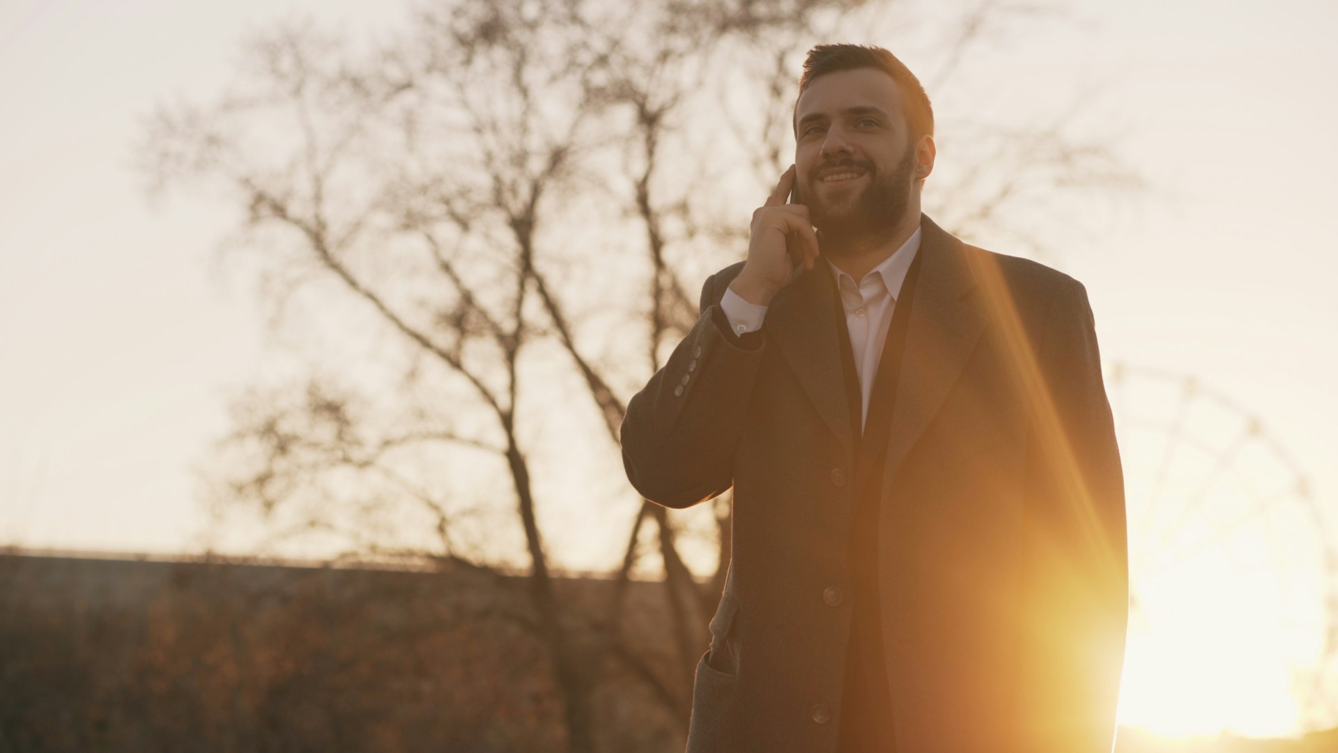 Man in suit talking on phone at sunset